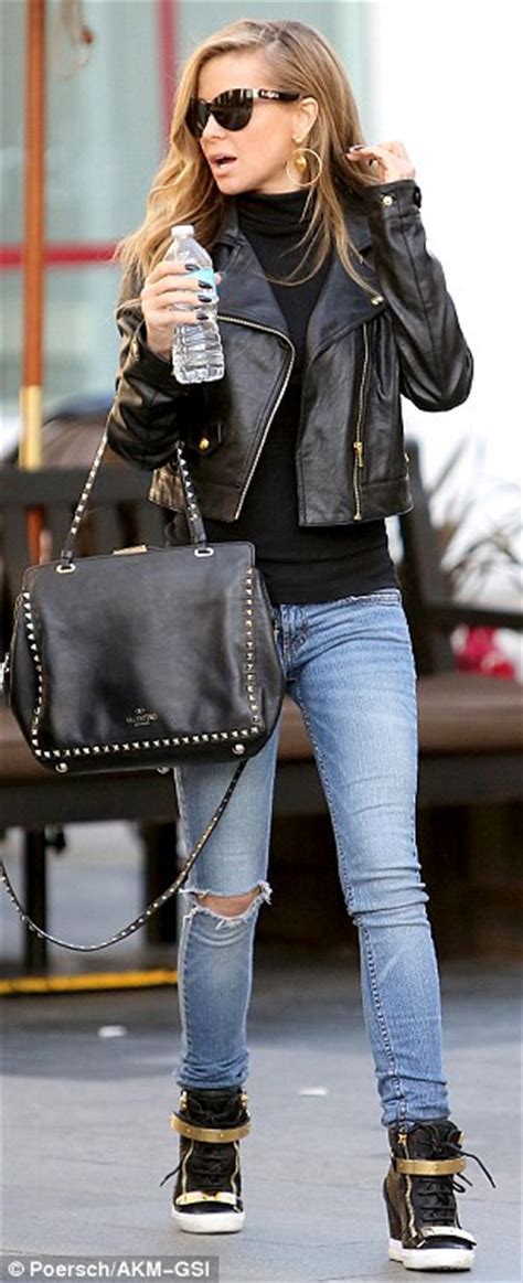 Carmen Electra sports ripped jeans, leather jacket and ...